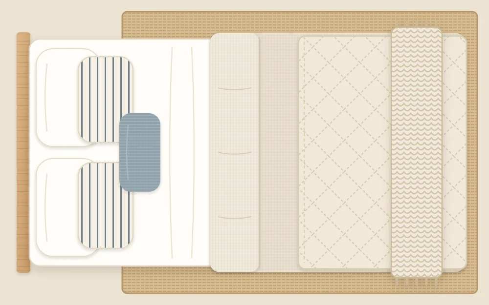 Bed seen from above with its layers stepped back in order: sheet, folded duvet, quilt, knit throw at the foot and three rows of pillows