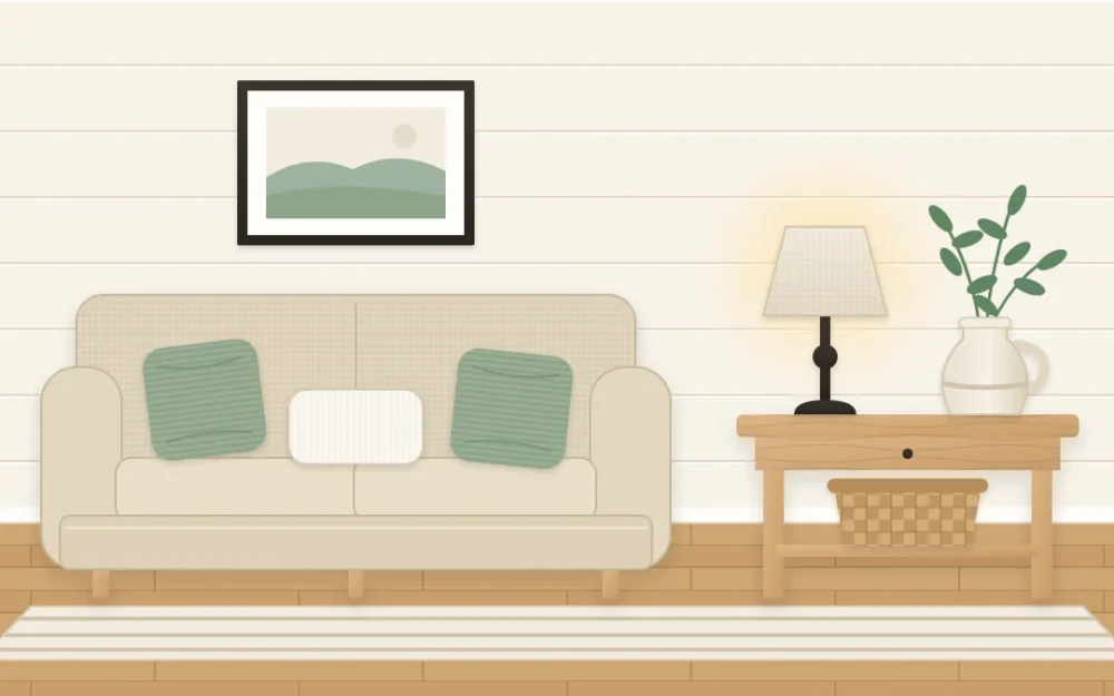 Farmhouse sofa corner with a warm white plank wall, oat sofa, two sage green cushions, a black metal lamp and a honey wood table with a cream jug