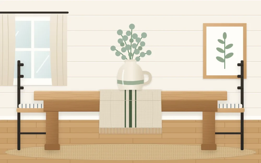 Oat linen runner with frayed ends and three thin stripes on a wooden dining table, with a small jug of greenery on top